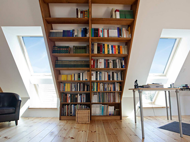 Bücherregal in einer Dachgeschosswohnung mit Dachfenster in Tandem-Einbauweise