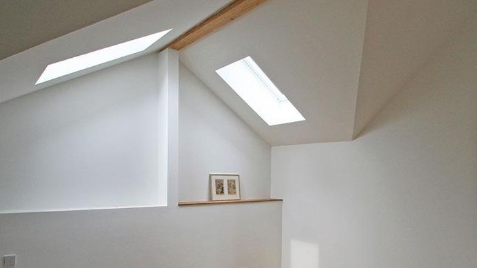 Licht fällt in ein Dachgeschoss mit zwei eingebauten Dachfenstern